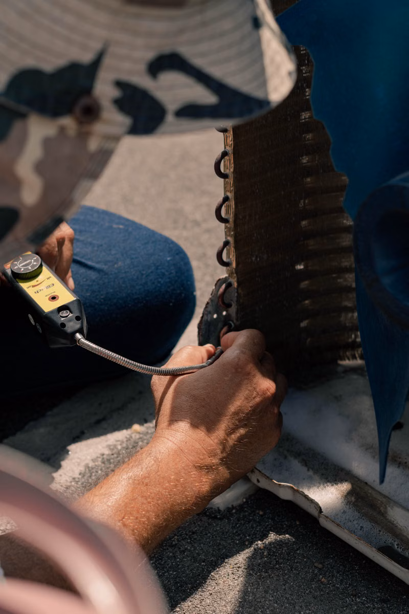 Heating technician testing a residential furnace with diagnostic tools